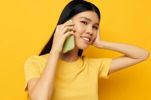 encantador joven asiático mujer hablando en el teléfono posando tecnología estudio modelo inalterado foto