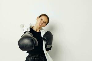 atlético mujer en boxeo guantes en negro pantalones y un camiseta aislado antecedentes foto