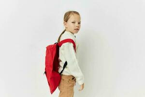 pretty young girl school backpack with a hat on his head isolated background photo