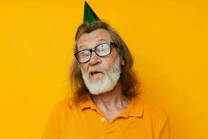 Portrait elderly man in a yellow t-shirt with a cap on his head fun yellow background photo