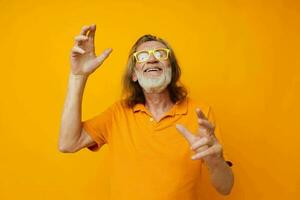 elderly man in yellow glasses with a gray beard emotions yellow background photo