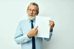 Portrait of happy senior man in a shirt with a tie copy-space sheet of paper cropped view photo