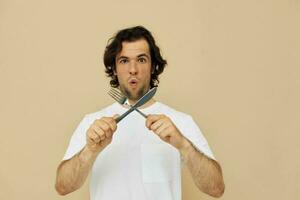 hermoso hombre emociones cuchillo y tenedor batería de cocina aislado antecedentes foto