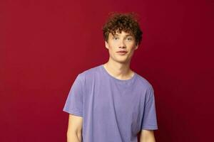 teenager in purple t-shirts posing emotions isolated background unaltered with a cap on his head photo