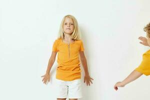 a boy and a girl in yellow T-shirts are standing next to each other on a light background posing photo