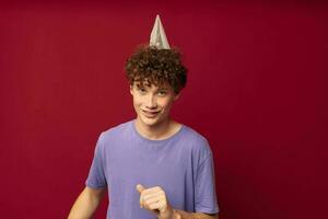 teenager in purple t-shirts posing emotions isolated background unaltered with a cap on his head photo