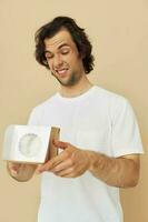 Cheerful man in a white t-shirt with a gift box photo