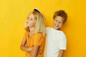 a boy with a comb combing a girl's hair yellow background photo