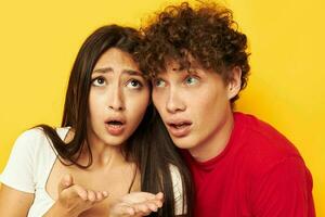 young boy and girl together posing emotions close-up yellow background unaltered photo