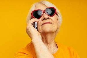 Photo of retired old lady happy lifestyle in yellow t-shirts glasses cropped view