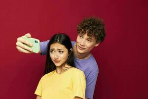 bonito chico y niña en vistoso camisetas con un teléfono juventud estilo foto