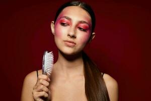 pretty woman with a comb in hand bright makeup posing fashion emotions studio model photo