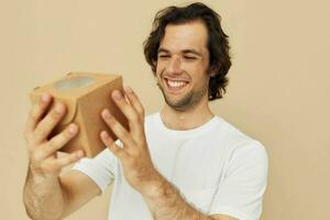 emocional hombre con regalo pequeño caja en beige antecedentes foto