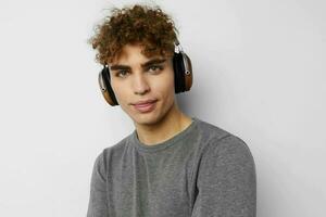 hermoso joven hombre escuchando a música en auriculares emociones aislado antecedentes foto