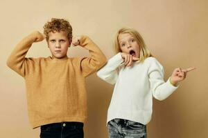 pequeño chico y niña en suéteres juntos divertido infancia inalterado foto