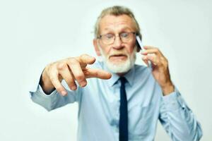 old man with the phone shows to the camera in the studio on a white background photo