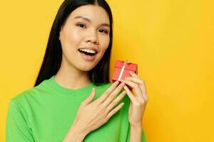 Portrait Asian beautiful young woman with a small gift box holiday yellow background unaltered photo