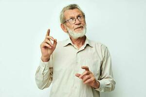 Photo of retired old man with a gray beard in a shirt and glasses light background