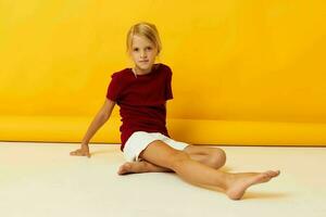 Girl sitting on the floor posing yellow background photo