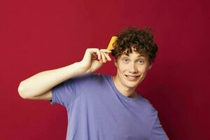 portrait of a young curly man posing hairbrush personal care Youth style photo