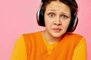 pretty woman in an orange sweater headphones music entertainment cropped view unaltered photo