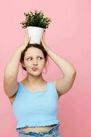 funny girl in a blue T-shirt and shorts a flowerpot isolated backgrounds unaltered photo
