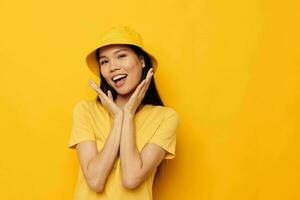 mujer en un amarillo camiseta y sombrero posando emociones aislado antecedentes inalterado foto