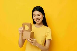 woman holding a small box gift yellow background photo