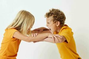 Portrait of cute children in yellow t-shirts standing side by side childhood emotions unaltered photo