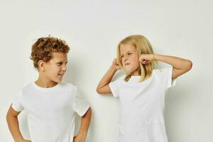 Boy and girl in white T-shirts are standing next to isolated background photo