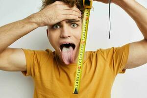 Attractive man grimace measuring tape posing Lifestyle unaltered photo