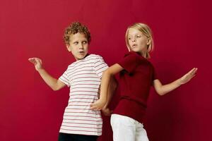 Small children good mood standing next to posing red background photo