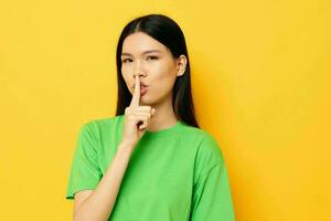 Charming young Asian woman in green t-shirts gestures with his hands emotions studio model unaltered photo