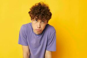 guy with curly hair in purple t-shirts studio yellow background photo