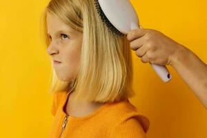 little girl combing blonde hair dissatisfaction photo