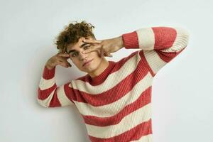 handsome young man in a striped sweater posing Lifestyle unaltered photo