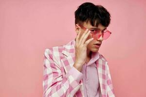 portrait of a young man pink glasses checkered jacket fashion posing pink background unaltered photo