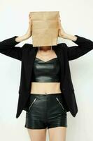 beautiful woman in a leather suit black jacket with a bag on his head isolated background photo