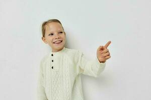 cheerful little girl in a white sweater hand gesture photo