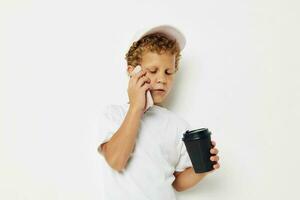 cute boy in a white t-shirt cap with a phone in a glass with a drink lifestyle unaltered photo