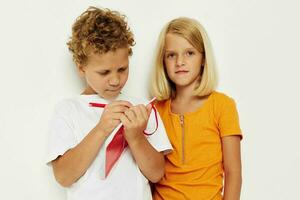 two joyful children stand next to notepad pencil drawing emotions lifestyle unaltered photo