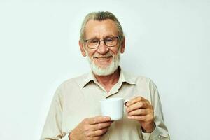 an elderly man holding a mug on a white background and smiling photo