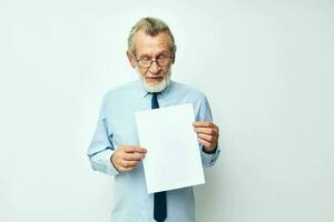 foto de retirado antiguo hombre participación documentos con un sábana de papel ligero antecedentes