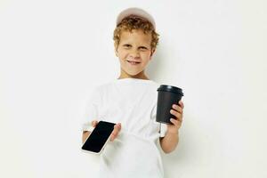 linda pequeño chico hablando en el teléfono con un negro vaso ligero antecedentes inalterado foto