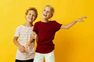 Small children standing side by side posing childhood emotions on colored background photo