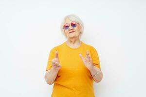 smiling elderly woman happy lifestyle in yellow t-shirts light background photo