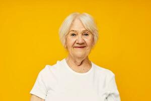 Photo of retired old lady in white t-shirt posing fun yellow background