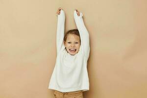 linda niña en blanco suéter posando mano gestos infancia inalterado foto