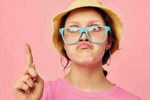 Young woman wearing a panama hat and glasses posing isolated background photo