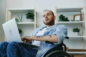 hombre en silla de ruedas persona de libre dedicación trabajando a ordenador portátil a hogar sonrisa, trabajando en línea, social redes y puesta en marcha, Copiar espacio, social integración, salud concepto hombre con discapacidades, real persona foto